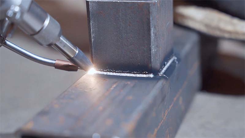 Robotic laser welding arm in industrial setting